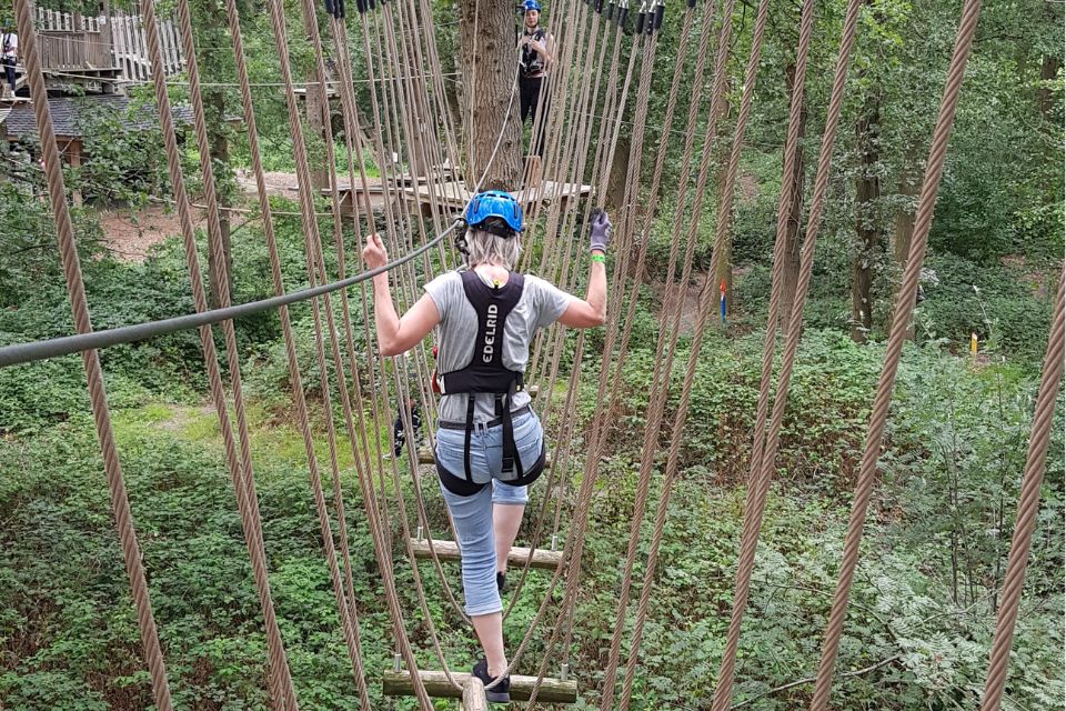 Vrouw op een klimparcours in het bos — verleg je grenzen en prikkel jezelf